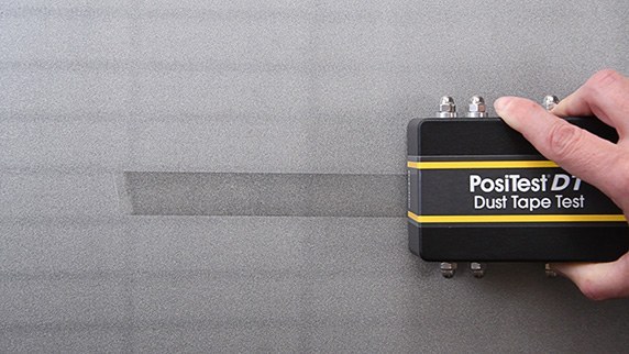 Tape roller applying uniform pressure during a dust tape test