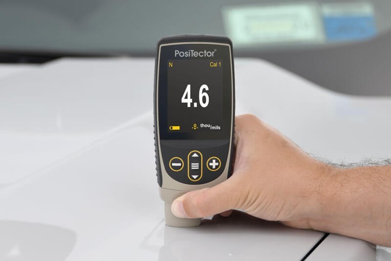 PosiTector 6000 FN1 measuring paint thickness on an aluminum automobile hood